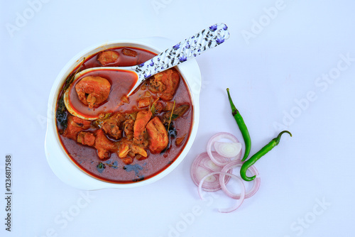 Cooked delicious chicken curry with spoon in a bowl
