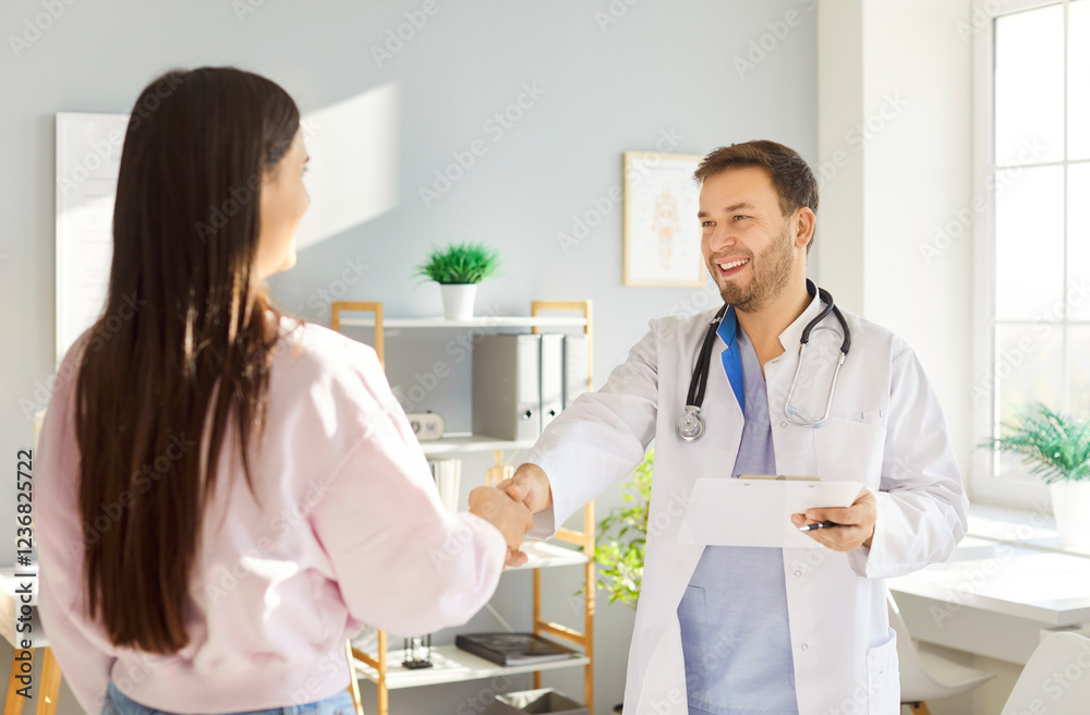 Smiling doctor in white coat shaking hands with female patient in medical office. Professional healthcare provider greeting patient with warm welcome, building trust and connection during visit. Smiling doctor in white coat shaking hands with female patient in medical office. Professional healthcare provider greeting patient with warm welcome, building trust and connection during visit.