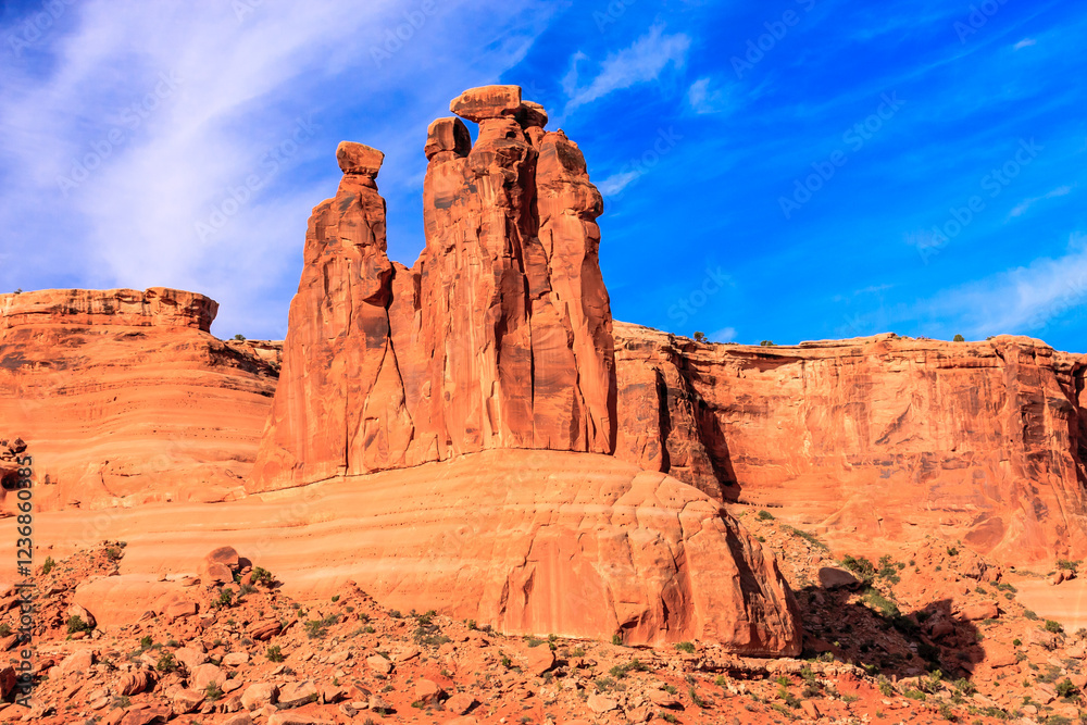 A large rock formation with two smaller rocks on top of it A large rock formation with two smaller rocks on top of it