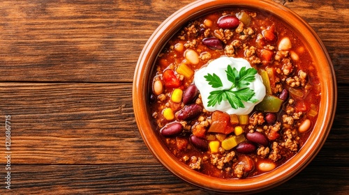 Delicious Chili Bowl Recipe - Hearty chili in a rustic bowl, topped with sour cream and parsley. Perfect for a cozy meal. photo