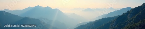 Mountain peaks shrouded in mist and sunlit fog, natural wonder, foggy, misty photo