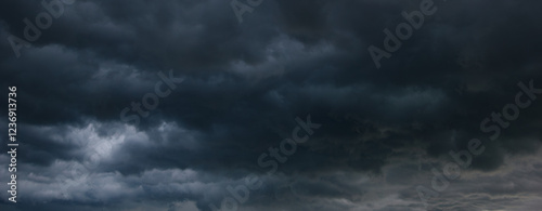 A stormy sky filled with dark, heavy clouds signals an impending windstorm, creating a dramatic and foreboding atmosphere that highlights the intensity of nature's power.