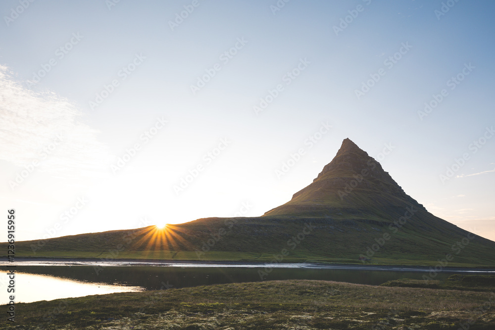 Kirkjufell mountain on the Snaefellsnes peninsula in Iceland during sunset. The iconic peak reflects over the calm waters, surrounded by vibrant colors of the evening sky Kirkjufell mountain on the Snaefellsnes peninsula in Iceland during sunset. The iconic peak reflects over the calm waters, surrounded by vibrant colors of the evening sky