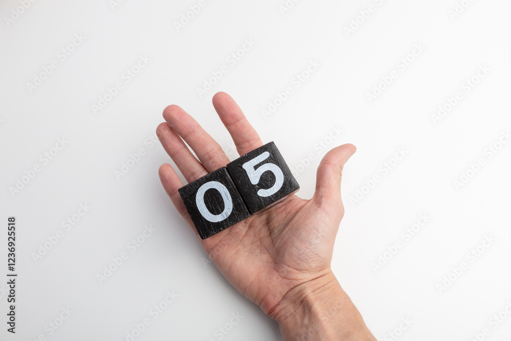 Hand Holding Wooden Blocks Showing Numbers Zero and Five on White Background Hand Holding Wooden Blocks Showing Numbers Zero and Five on White Background