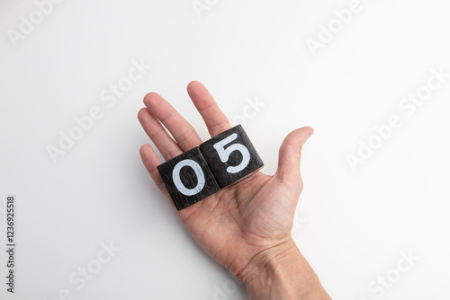 Wallpaper Mural Hand Holding Wooden Blocks Showing Numbers Zero and Five on White Background Torontodigital.ca
