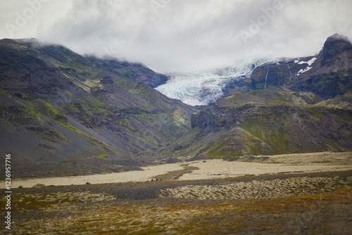 Scenic view of black volcanic mountains and Vatnajokull (Vatna glacier) in Iceland. photo