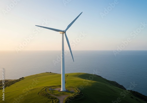 White wind turbines on a green hill under a clear blue sky photo