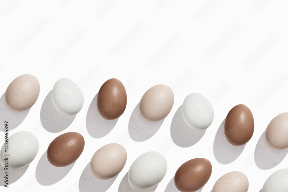 Top view Brown beige Eggs with shadows on light background, minimal trend food pattern from assorted natural Chicken egg with neutral color eggshells, Easter food celebration concept, monochrome