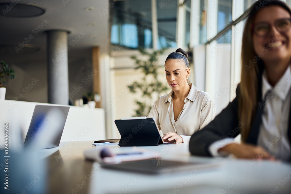 Focused Professionals Working in Modern Office Setting With Natural Light Focused Professionals Working in Modern Office Setting With Natural Light