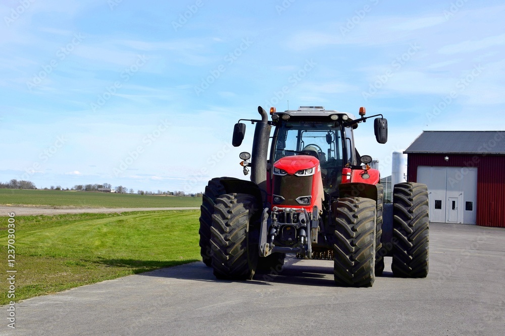A big red tractor stands in the yard. A big red tractor stands in the yard.