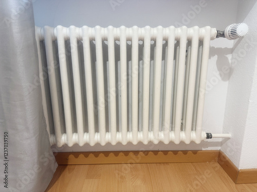 Wallpaper Mural White Cast Iron Radiator for Central Heating Under a Window. High quality photo A classic white cast iron radiator connected to a central heating system, installed under a window for optimal heat Torontodigital.ca