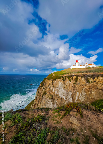 Cabo da Roca, the westernmost point of the continental Europe in Portugal. Picturesque view of a lighthouse on the rock on a sunny day photo