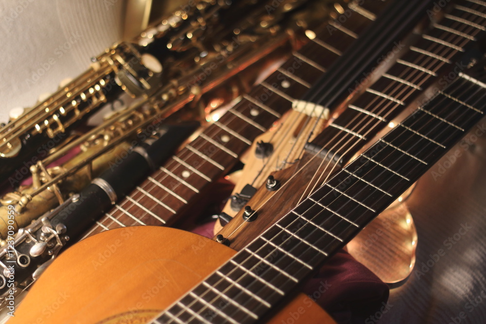 Fototapeta premium A close-up shot capturing the intricate beauty of a guitar, bass, and saxophone, bathed in warm golden light