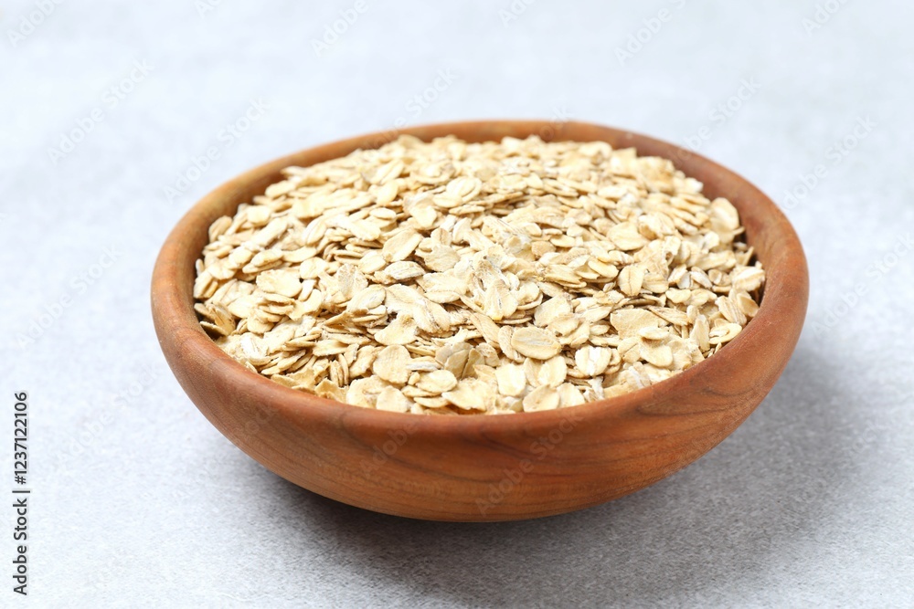 Composition with oatmeal flakes on gray background. Cooking breakfast