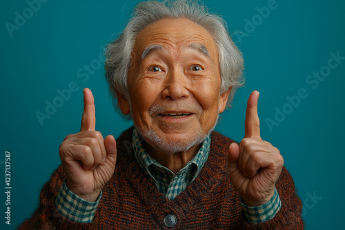 Portrait of an elderly Asian man on a blue background.