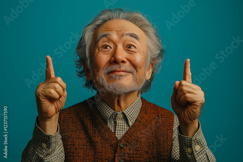 Portrait of an elderly Asian man on a blue background.