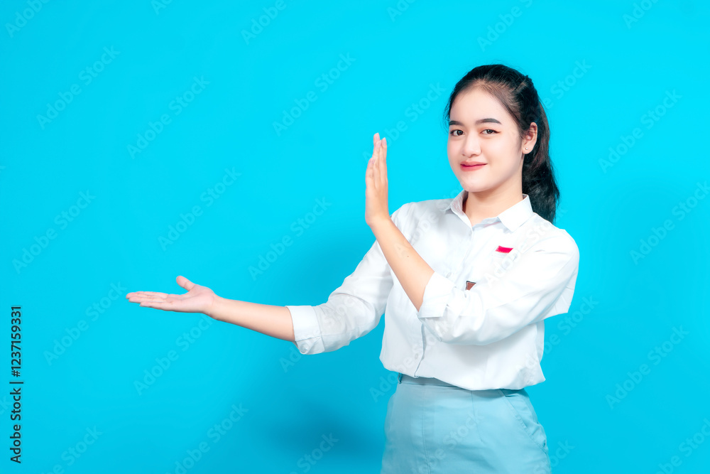 Young female student dressed in a uniform gesturing with open palms isolated a blue background Young female student dressed in a uniform gesturing with open palms isolated a blue background