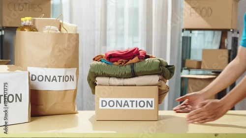 Recyclable clothing donation concept. Focusing on box containing by reusable clothes for those in need at a charity center. Donation, volunteer activities, humanitarian efforts, charitable initiatives