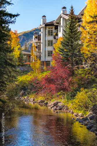 Vail, Colorado ski resort town cityscape river reflection of lodge hotel building swiss architecture in autumn fall season multicolored golden Aspens