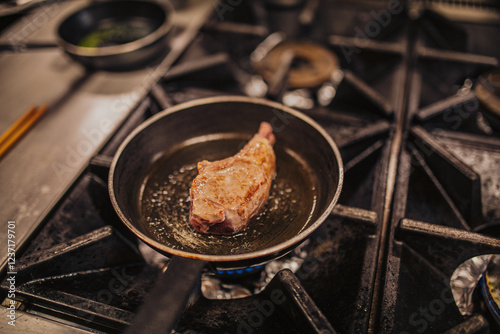  A large lamb chop meat cooking in frying pan with oil  photo