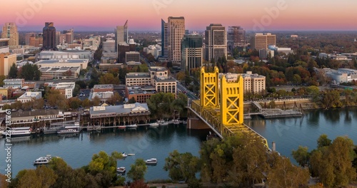 Fototapeta Naklejka Na Ścianę i Meble -  Tower Bridge, Sacramento, CA. Aerial view of the city, river, and bridge at sunset. Beautiful fall colors. Sacramento River, Sacramento, California, USA