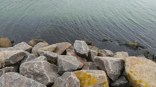 Top view of stones and sea water. Natural background. Sea texture.