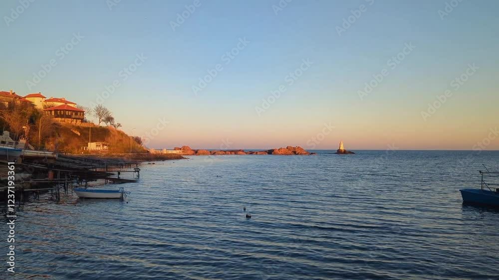 Ahtopol, Bulgaria. View of the lighthouse and calm sea at sunset. Ahtopol, Bulgaria. View of the lighthouse and calm sea at sunset.