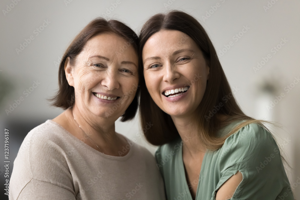 Close up portrait of two beautiful older and younger women. Elderly mother and young adult daughter posing for family album photo, smiling, look at camera, exuding joy, emotional closeness and warmth Close up portrait of two beautiful older and younger women. Elderly mother and young adult daughter posing for family album photo, smiling, look at camera, exuding joy, emotional closeness and warmth