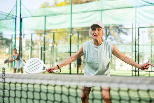 Wallpaper Mural Portrait of sporty fit senior woman playing padel on open court on summer day, ready to hit ball. Health and active lifestyle concept.. Torontodigital.ca