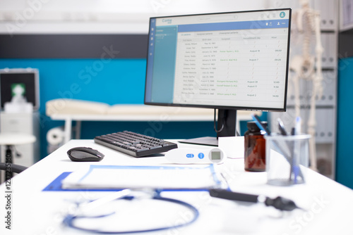 Clinical office with essential healthcare tool and medical data shown on computer screen ready for next patient. Vacant examination room with hospital bed and documents for upcoming appointments.