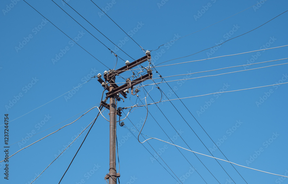 Rusty and old electric pole. Messy and tangled wires. blue sky. Rusty and old electric pole. Messy and tangled wires. blue sky.
