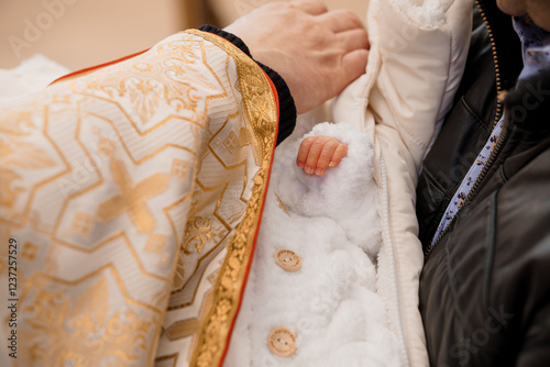 Baptism Ceremony with a Baby in a White Outfit and Ornate Robe photo