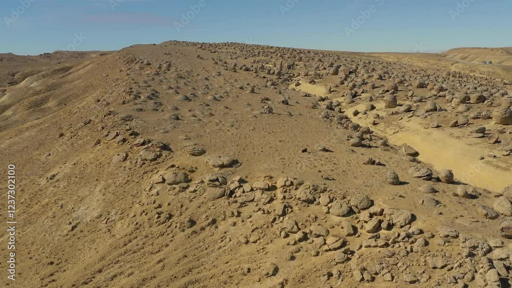 AKTAU, KAZAKHSTAN - FEBRUARY 1, 2025: Vast desert landscape showcasing unique boulders and rock formations under clear blue sky AKTAU, KAZAKHSTAN - FEBRUARY 1, 2025: Vast desert landscape showcasing unique boulders and rock formations under clear blue sky