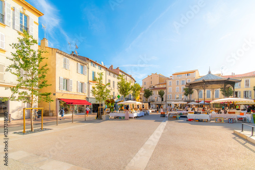 Fototapeta Naklejka Na Ścianę i Meble -  The weekly outdoor clothing and flea market at Place Amiral Barnaud in the Mediterranean seaside town of Antibes, France, on the French Riviera.