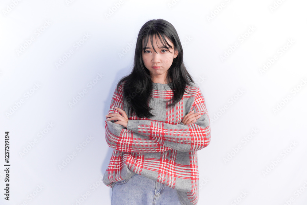 Indonesian Asian woman with long black hair wearing a red checked shirt with her arms crossed Indonesian Asian woman with long black hair wearing a red checked shirt with her arms crossed