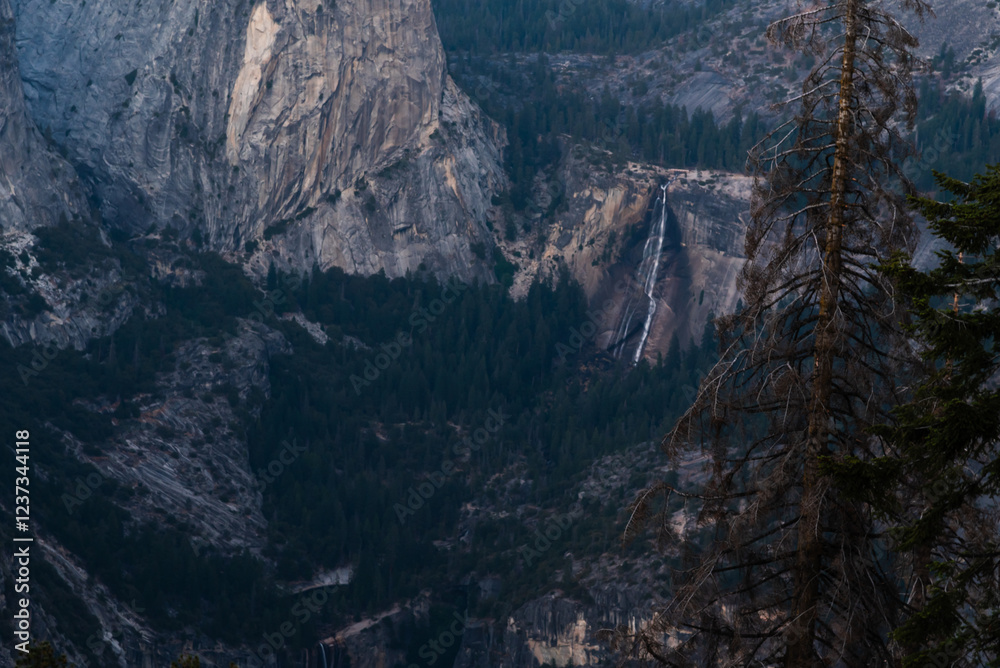 Yosemite mountain landscape with a distant waterfall and forest. Yosemite mountain landscape with a distant waterfall and forest.