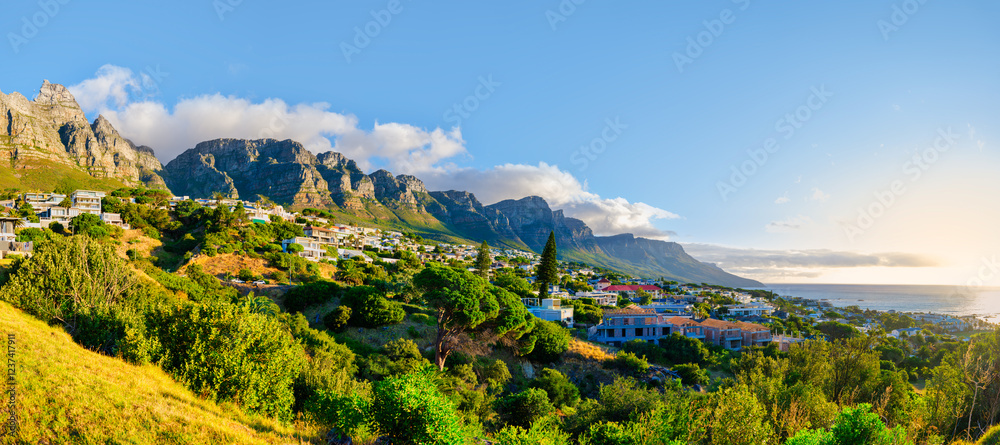 A panoramic shot of the stunning Twelve Apostles Mountain with Bakoven houses on its slopes during a breathtaking sunset in Cape Town, South Africa