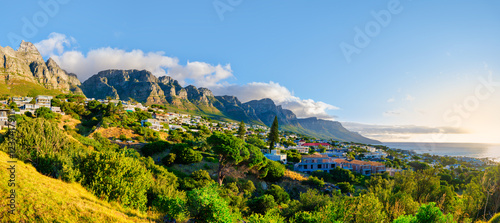 Obraz na płótnie A panoramic shot of the stunning Twelve Apostles Mountain with Bakoven houses on its slopes during a breathtaking sunset in Cape Town, South Africa w salonie