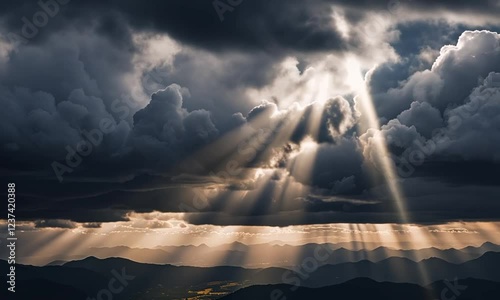 Dramatic cloudscape with sun rays over mountain range.