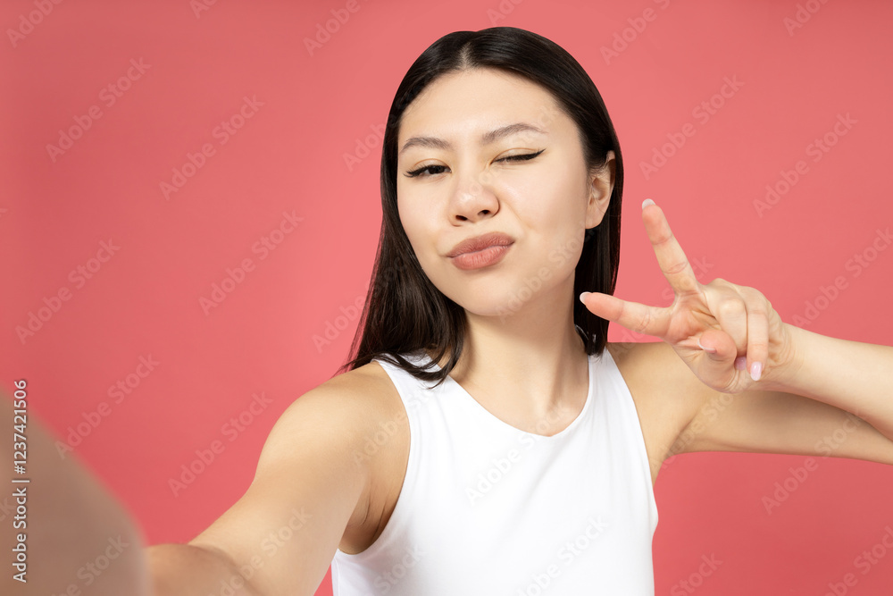Asian girl posing for a photo, on a pink background. Asian girl posing for a photo, on a pink background.