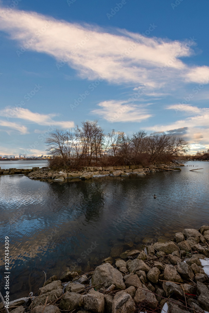 Winter island scene: leafless trees, calm water, and a clear blue sky. Winter island scene: leafless trees, calm water, and a clear blue sky.