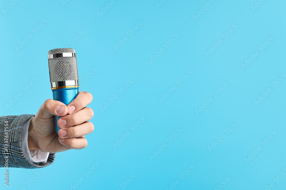 Man with microphone on light blue background, closeup. Space for text Man with microphone on light blue background, closeup. Space for text