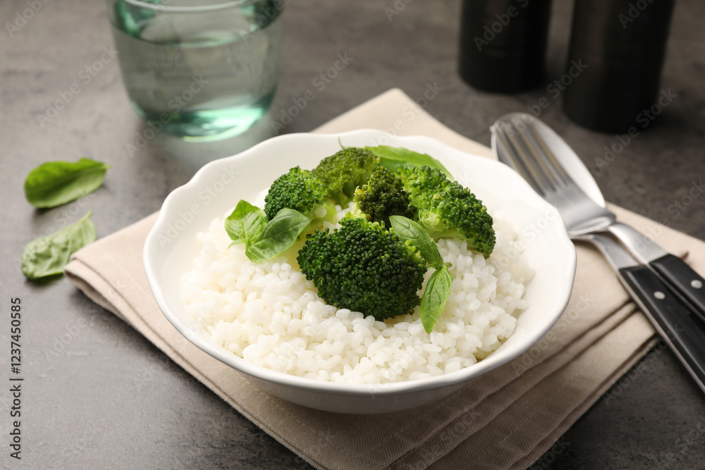Tasty rice with broccoli served on grey table, closeup Tasty rice with broccoli served on grey table, closeup