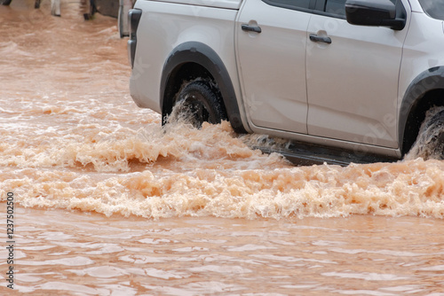 Muddy rain from a heavy rainy season flooded main roads connecting the district, making it difficult for cars to pass through and causing engine failures, in motion, car insurance concept, in motion.