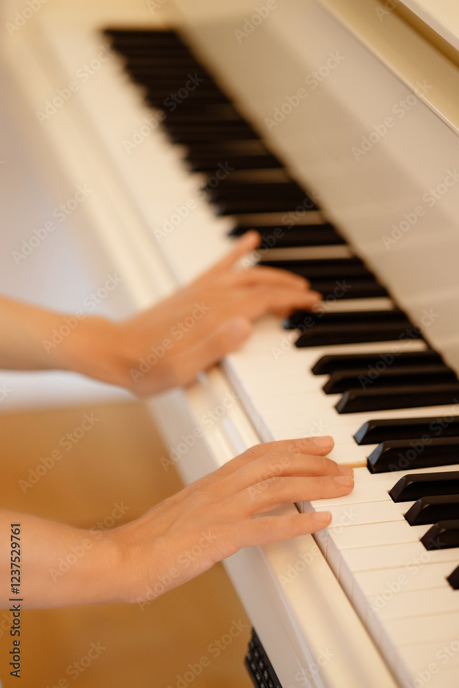 Fototapeta premium Lady playing piano with selective focus and shallow depth of field. High quality photo