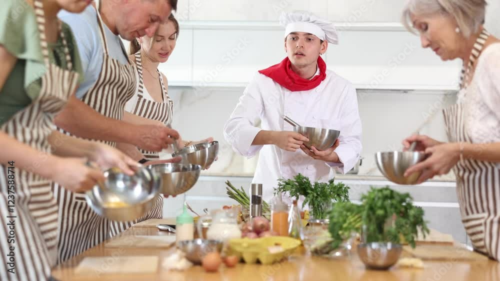 Friendly positive young guy, qualified chef, running culinary courses for mixed age group of ordinary passionate people, sharing professional secrets of cooking Friendly positive young guy, qualified chef, running culinary courses for mixed age group of ordinary passionate people, sharing professional secrets of cooking