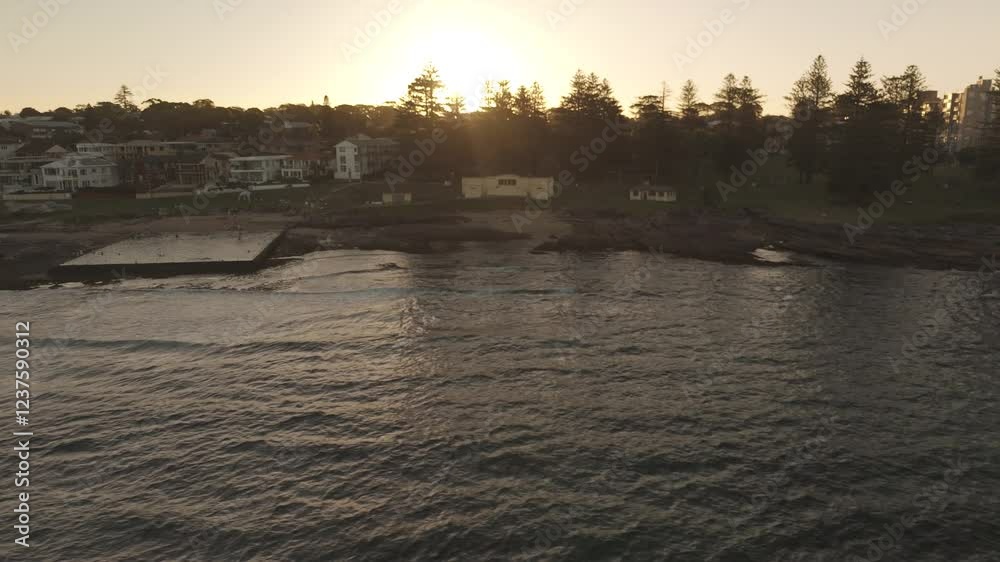 Aerial drone view past Shelly Beach Ocean Pool in Cronulla in the Sutherland Shire, South Sydney, NSW Australia during late afternoon summer in February 2025   