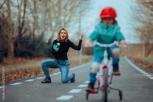 Mother Shouting in a Loudspeaker at her Daughter on a Bike. Authoritative mom yelling instruction at her cycling daughter 
