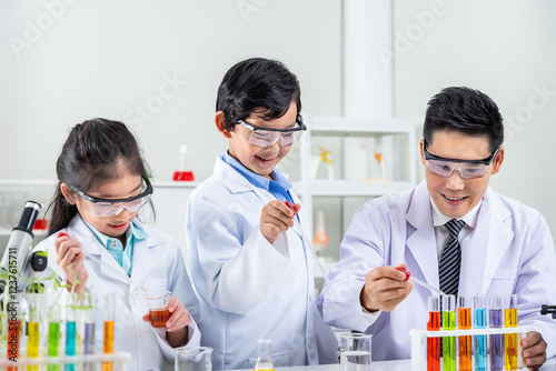 Asian boy and girl children pupils kids learning chemistry experiments with teacher in laboratory class