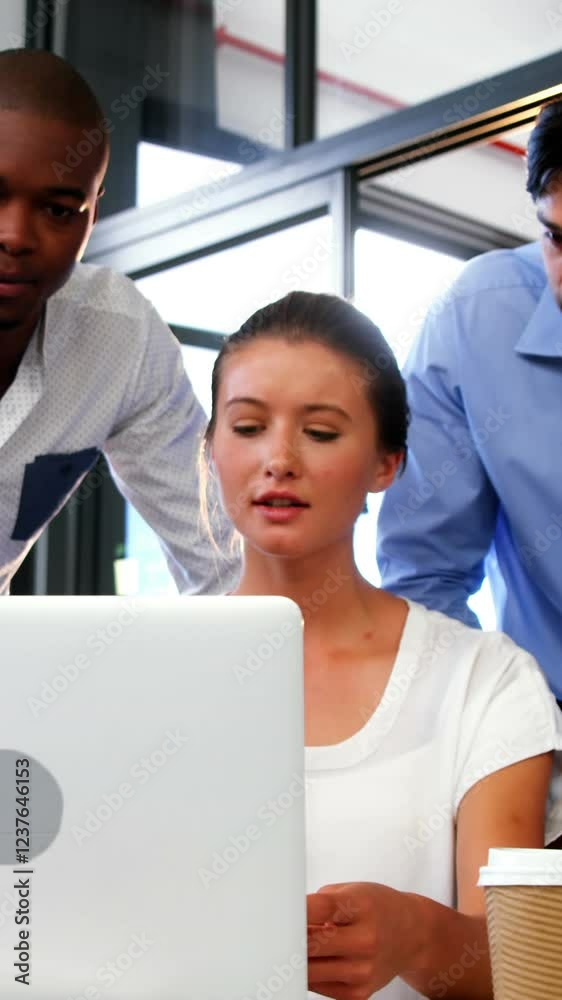 Business executives discussing over laptop and digital tablet Business executives discussing over laptop and digital tablet
